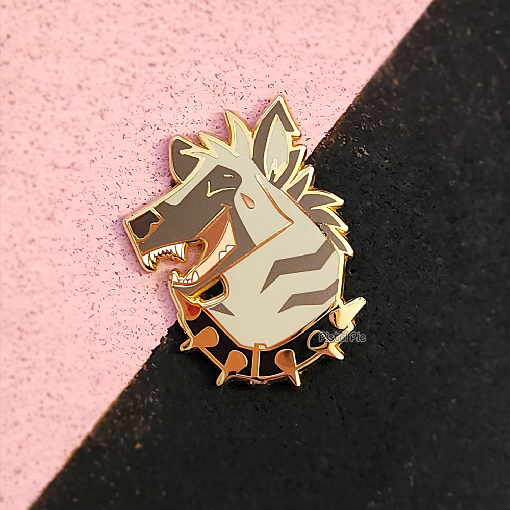 photo of enamel pin by pistol pie of a laughing striped hyena with a spiked collar