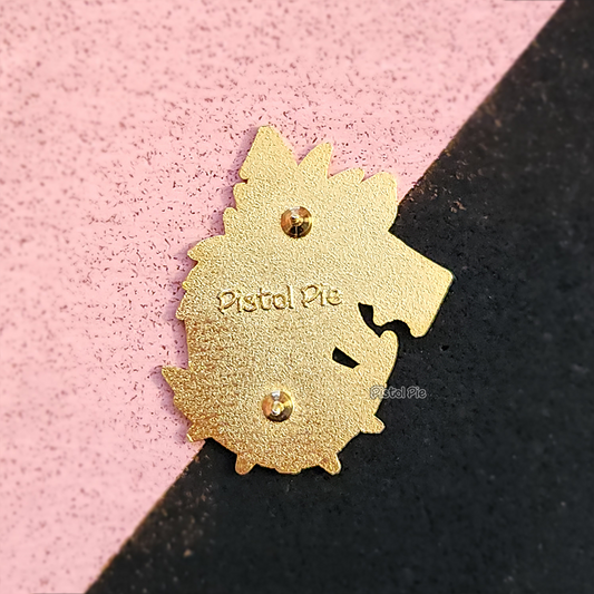 photo of the back of a gold enamel pin in the shape of a hyena with pistol pie logo embedded into the back