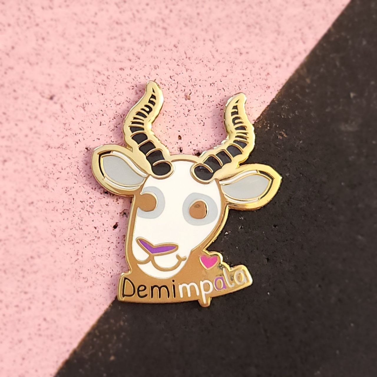 Enamel pin on pink and black background