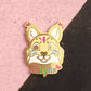 Enamel pin of a cartoon-like fface with 'Polynx' on a pink and black background