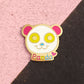 Colorful panda-themed pin on a pink and black background